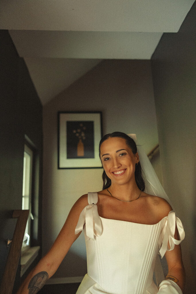 Bride posing for a portrait on the stairs of her home in Clarkston, Michigan.