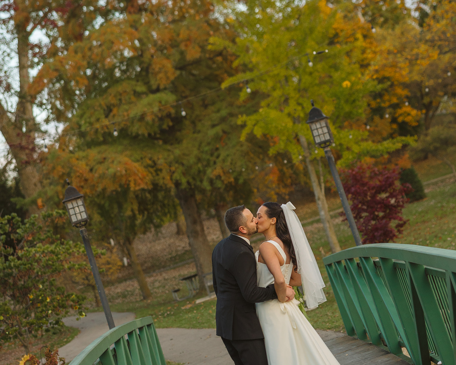 Bride and groom kissing on the bridge at Depot Park in Clarkston, Michigan.
