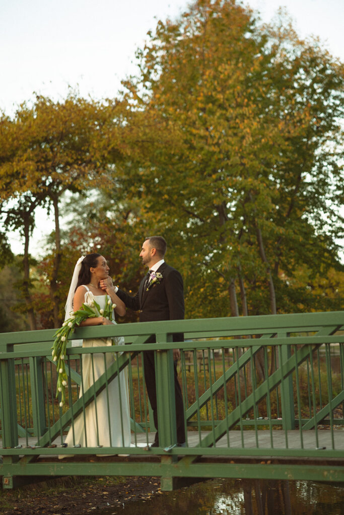 Bride and groom sharing a quiet moment together on a bridge during fall portraits at a Clarkston Michigan wedding.