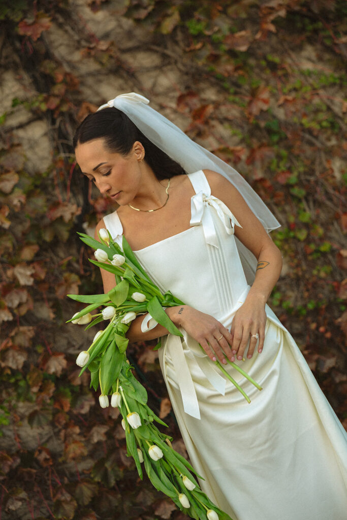 Close up outdoor portrait of the bride holding a waterfall bouquet.