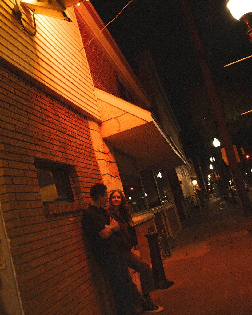 Couple posing outside of The Evening Post Bar & Grill in Clare, Michigan.
