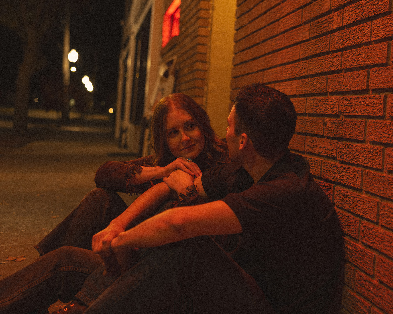 Couple sitting together outside of their local dive-bar.