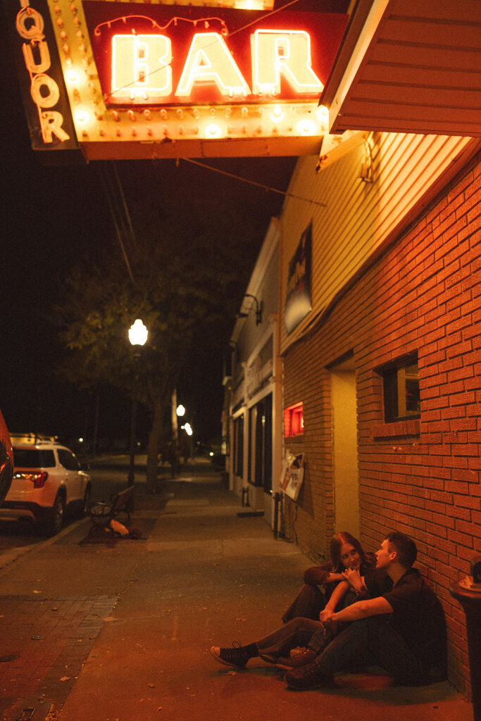 Couple sitting together outside of a dive-bar in Clare, Michigan.