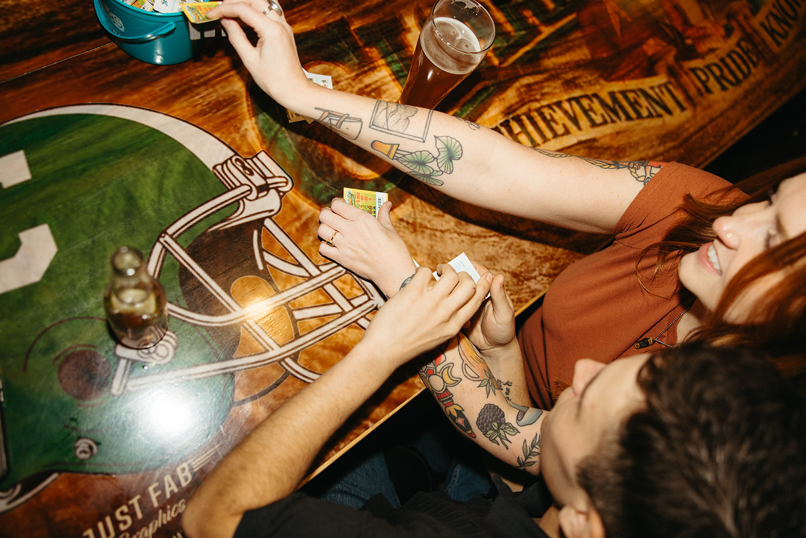 Close up shot of a couple playing pull tabs at The Evening Post Bar & Grill in Clare, Michigan for dive bar engagement photos.