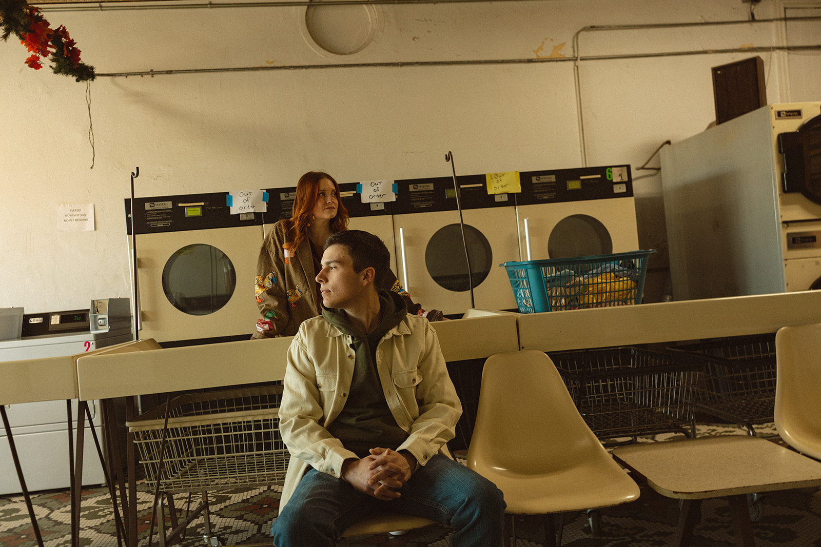 Editorial style photo of a couple posing at a laundromat in Michigan.