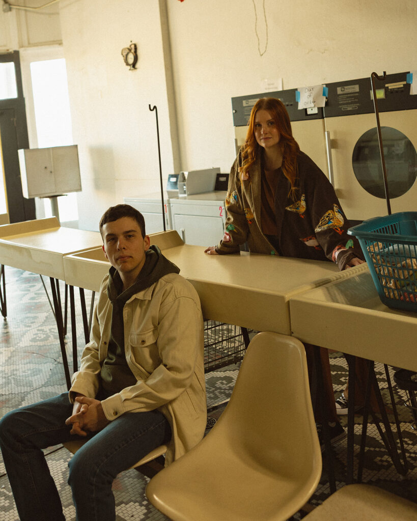 Editorial style photo of a couple posing at a laundromat in Michigan.