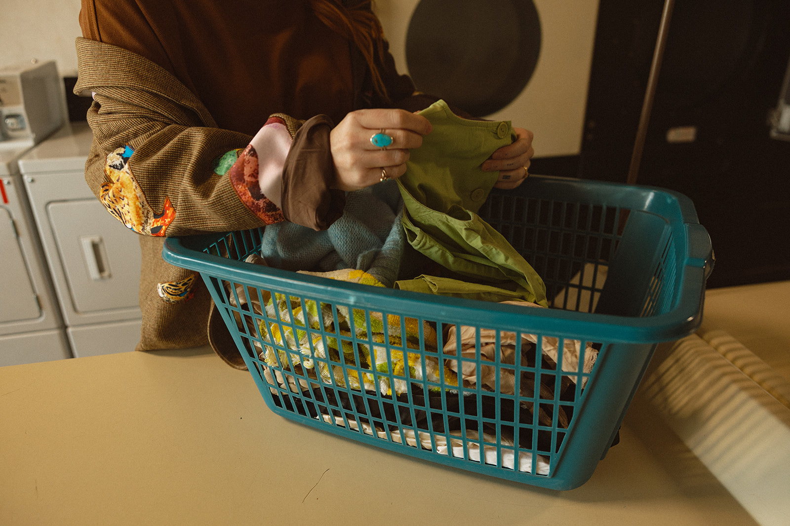 Woman folding laundry at a laundromat. 