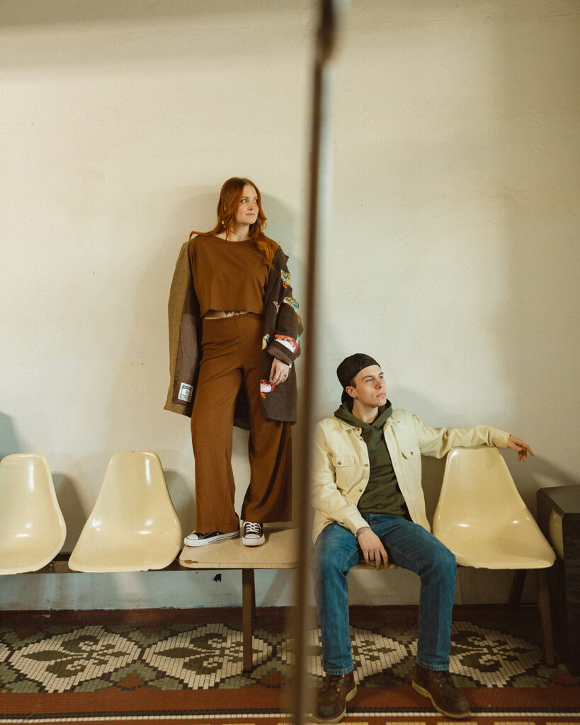 Couple posing on the seats at a local laundromat for their photoshoot.