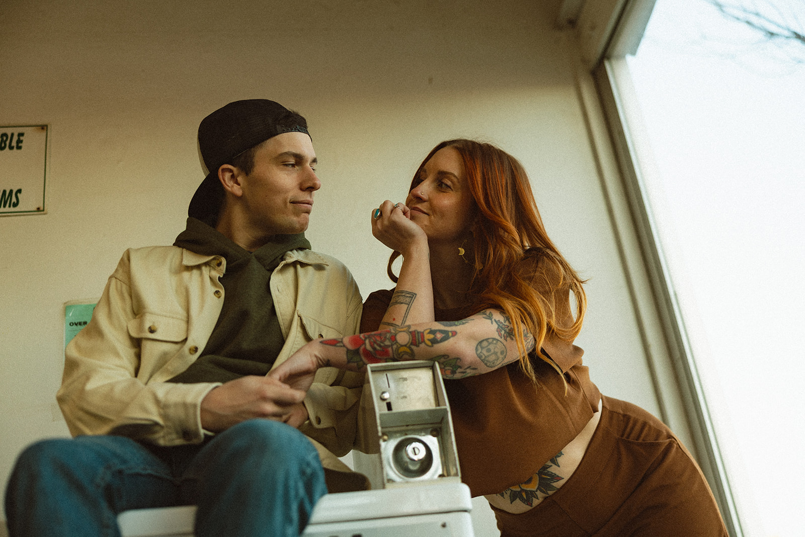 Couple posing next to a washing machine at a local laundromat in Michigan.