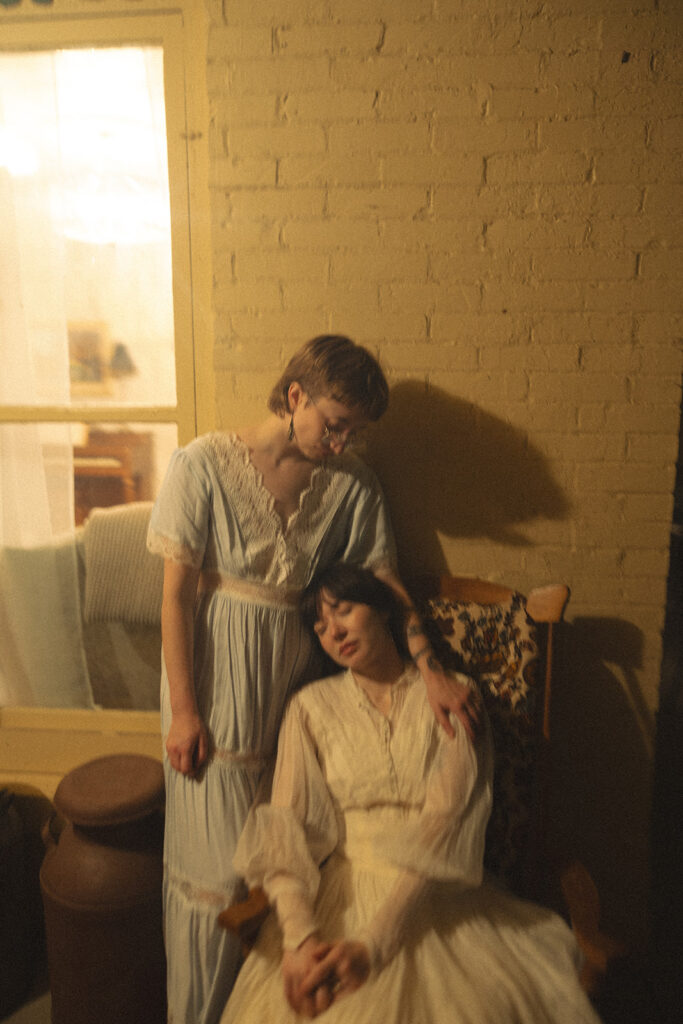 Couple posing together on the porch of a vintage farmhouse.