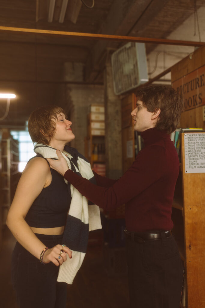 Couple inside John K. King Books doe their indoor Detroit winter engagement photos.