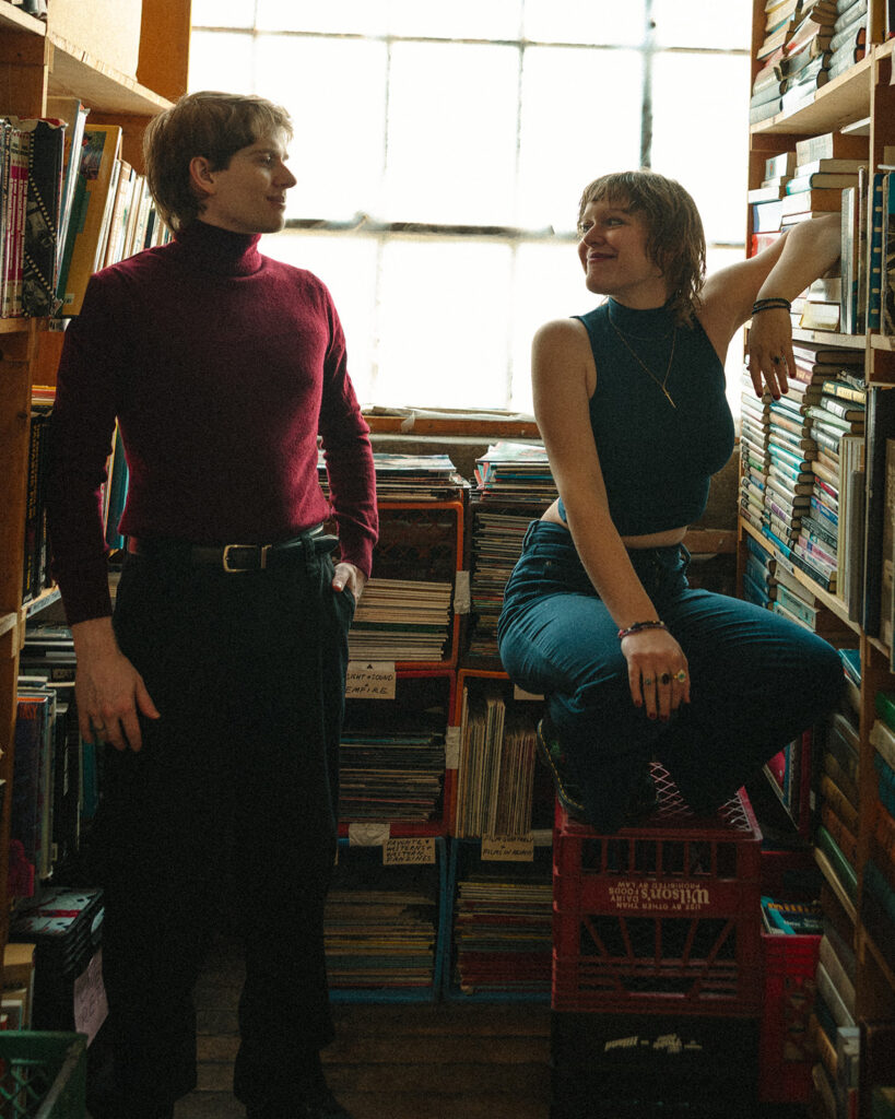 Couple sitting inside John K. King Books during their indoor Detroit winter engagement photos.