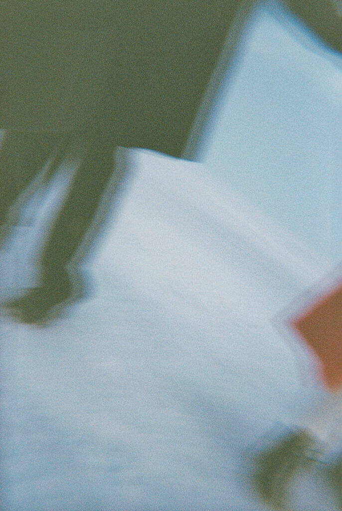Abstract film detail of a couple’s boots and red coat moving through the snow during their Detroit winter engagement photos.