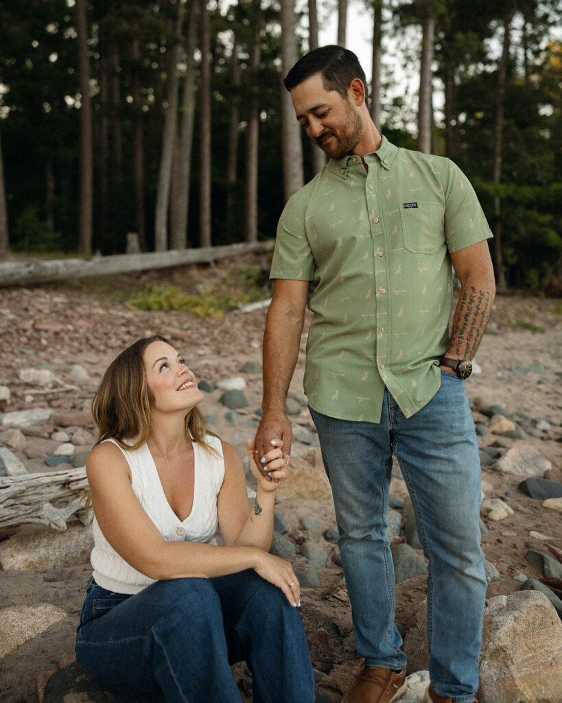 Couple holding hands as they pose for their Marquette engagement photos in Little Presque Isle.