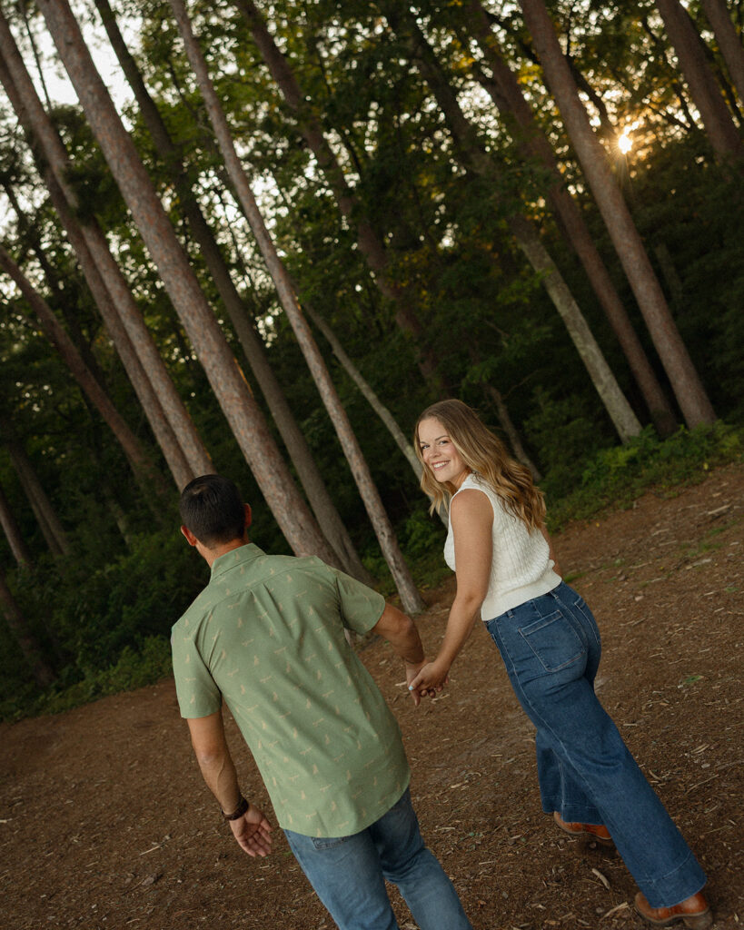 Couple walking and holding hands for their Marquette engagement photos on Little Presque Isle.
