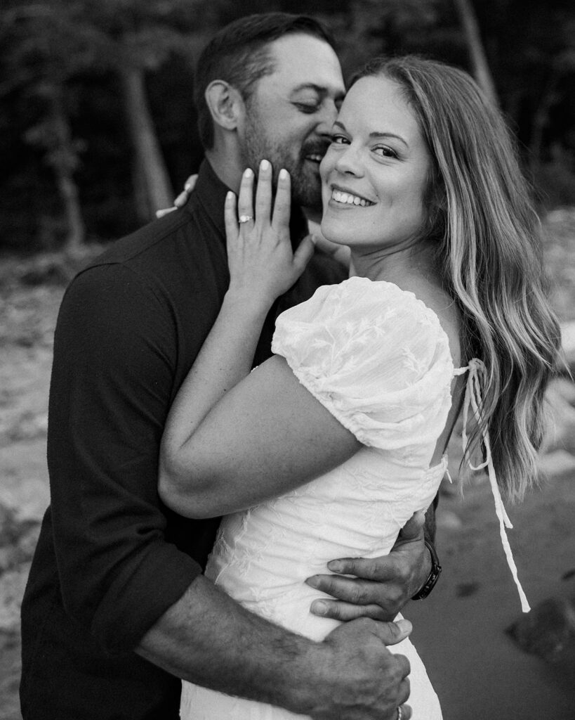 Man kissing his fiancé on the cheek during their Michigan engagement photos.