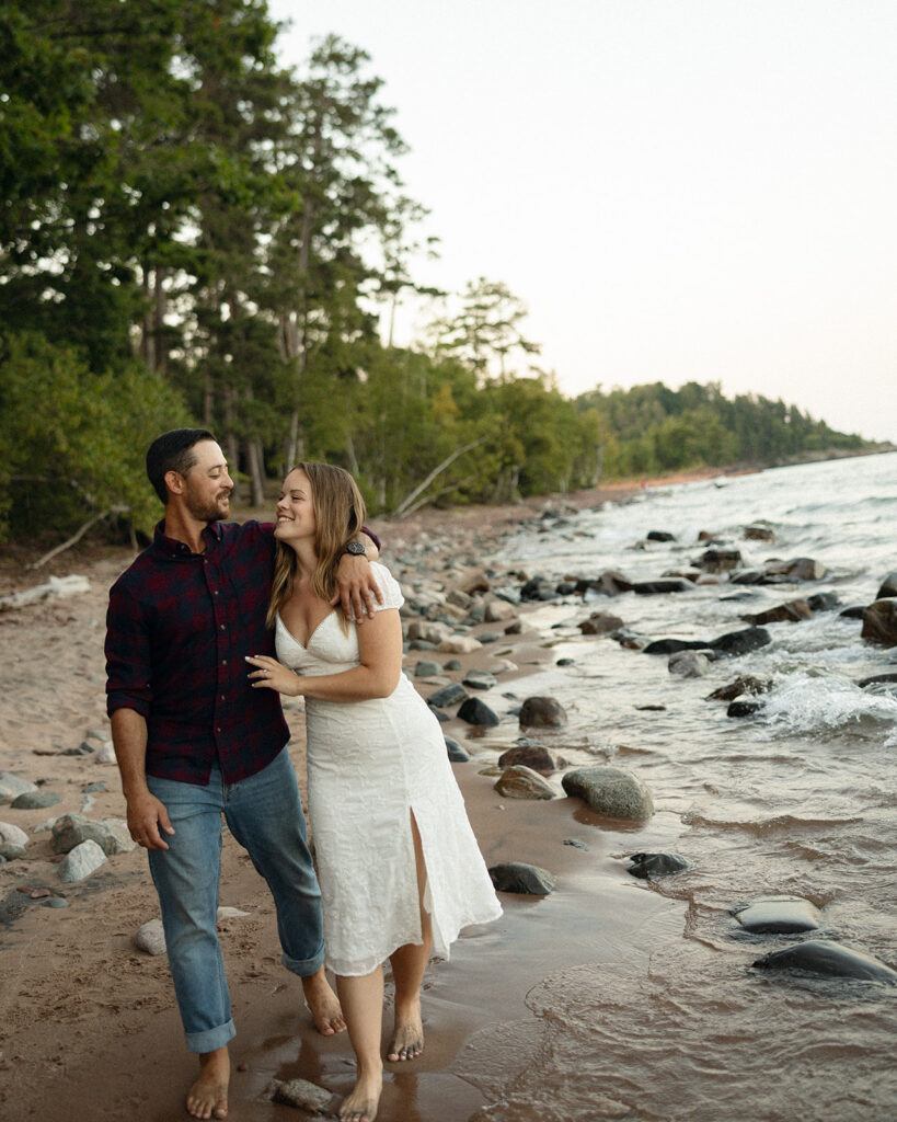 Couple walking on the beach during their engagement session at Little Presque Isle.