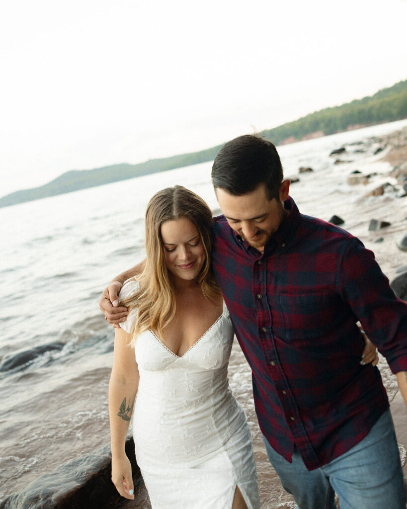 Couple walking on the beach during their engagement session at Little Presque Isle.