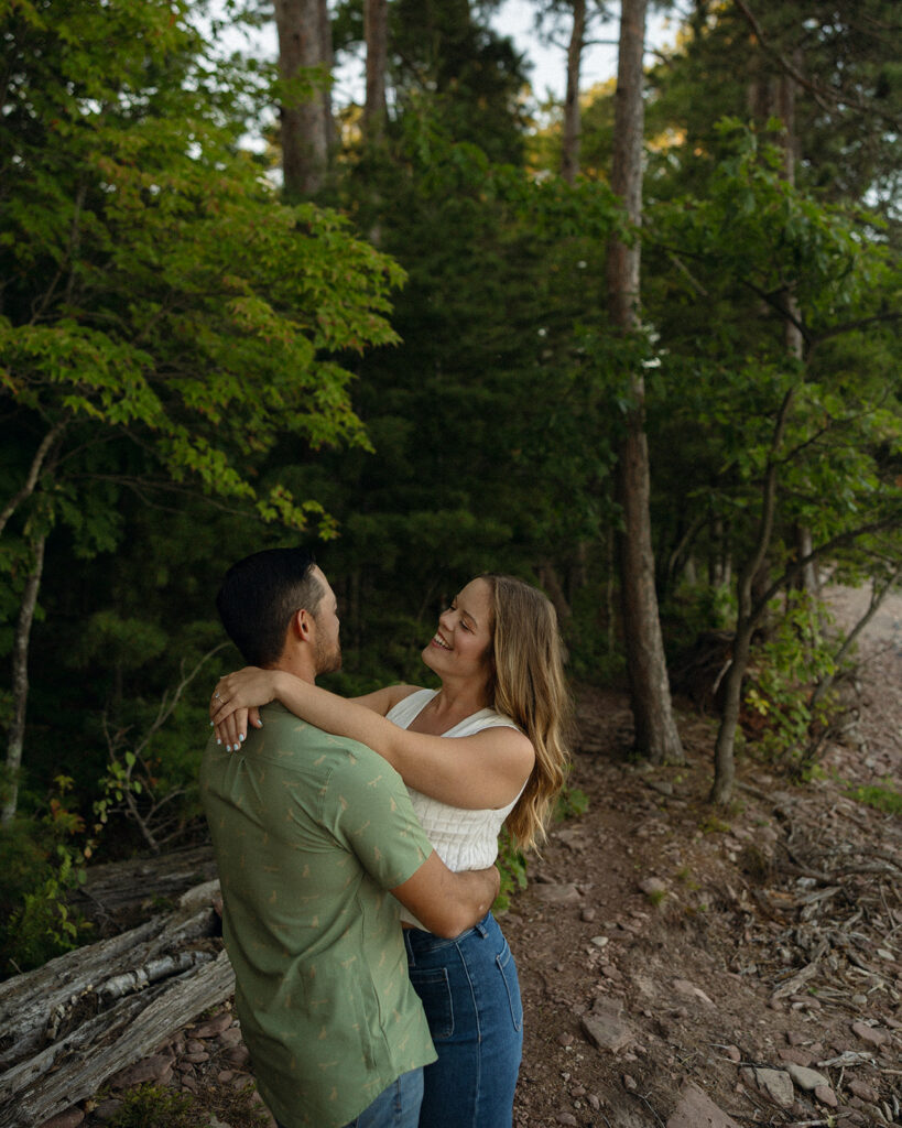 Couple holding onto one another for their Marquette Michigan engagement photos.