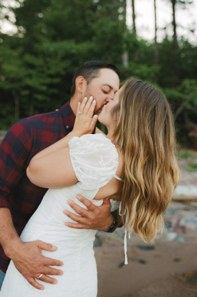 Close-up film photo of a couple kissing during their Little Presque Isle engagement session.